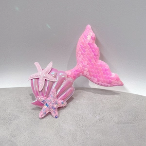 Detailed view of pink sequin mermaid tail hair clip with glitter starfish and shell accents