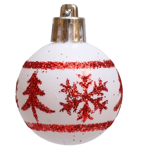 Close-up of white Christmas ball ornament with red glitter snowflake and tree patterns