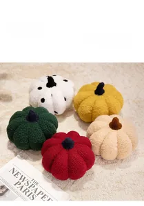 Detail of plush pumpkin pillows in various colors like mustard, green, and cream on a rug