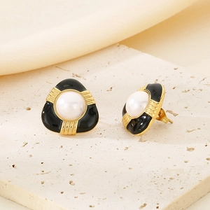 Detail of vintage French gold earrings with black resin inlay and white center pearl