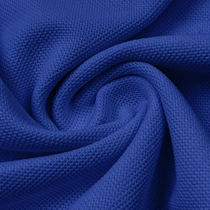 Macro view of breathable royal blue piqué knit fabric with honeycomb texture for polo shirts