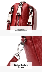 Detail of red pebbled leather bag featuring silver zippers and detachable metal hooks