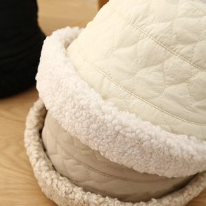 Détail de chapeaux bobs d'hiver matelassés avec bordure en laine d'agneau en beige et marron