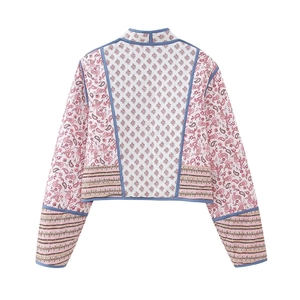 Detail of bohemian floral pattern and blue piping on reversible quilted jacket