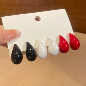 Detailed view of teardrop stud earring set in red, black, and white high gloss resin
