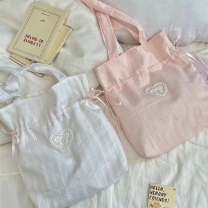 Dettaglio della borsa tote in tela con ricamo a cuore e coulisse in nastro rosa