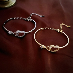 Elegant gold and silver interlocking heart bracelets with zircon on brown silk