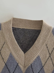 Detailed close-up of Argyle knit pattern and V-neckline texture on sleeveless sweater vest