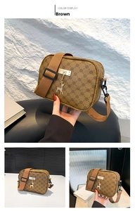 Detail of a brown patterned crossbody bag featuring a golden deer pendant and wide strap
