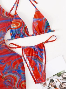 Detailed flat lay of three-piece bikini set with marble print and matching sarong skirt