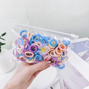 Close-up of colorful elastic hair bands with daisy decor in a clear zipper bag