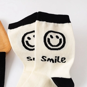 Mid-calf cream cotton socks with black smile pattern and Smile text in athletic style