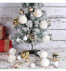 Dettaglio di palline di Natale assortite oro e bianco su un albero festivo innevato