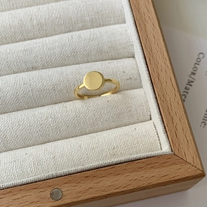 Detailed view of gold S925 sterling silver minimalist round plate ring in a wood box