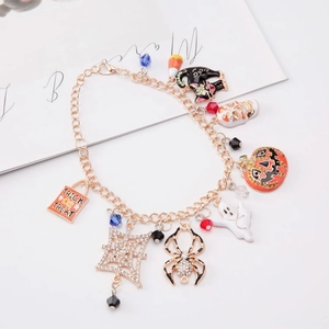 Halloween charm bracelet with pumpkin ghost and trick or treat tags on golden chain