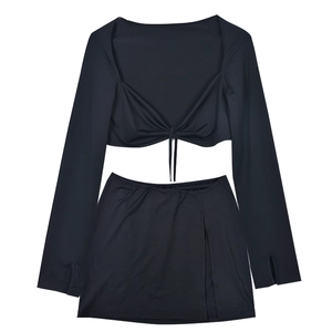 Detail of black two-piece set featuring V-neck drawstring crop top and side slit mini skirt