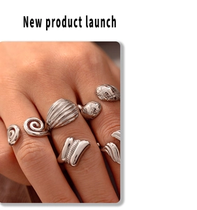 Detailed view of stacked silver textured spiral and wavy minimalist titanium rings on fingers