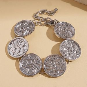 Detailed view of silver metal bracelet featuring textured circular disks and chain