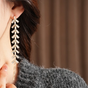 Macro shot of silver leaf tassel earrings with sparkling cubic zirconia on a model