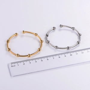 Detail of twisted wire stainless steel bangles in gold and silver with size measurement