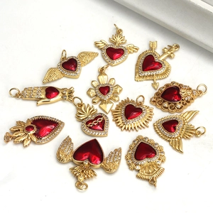 Detailed view of assorted gold heart pendants with red enamel and crystal wings
