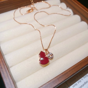 Detailed close-up of red enamel Wu Lou pendant with rose gold chain in a jewelry box