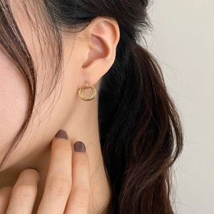Detailed close-up of a model wearing minimalist triple-hoop gold earrings for women