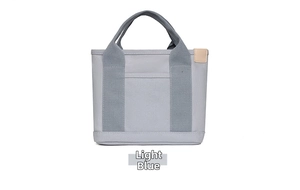 Detailed front view of light blue canvas tote bag with reinforced handles and side leather tag