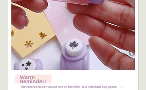 Close-up of handheld manual craft punch creating bear and snowflake shapes on paper