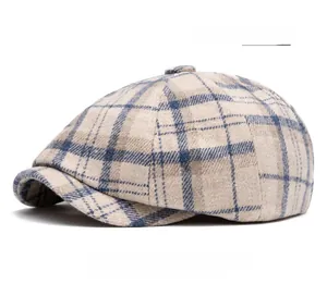 Dettaglio del berretto newsboy a quadri beige con trama in lana e stile britannico