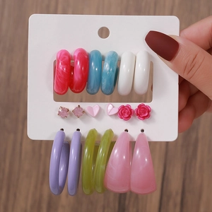 Detailed set of acrylic hoop earrings and heart studs displayed on a white card