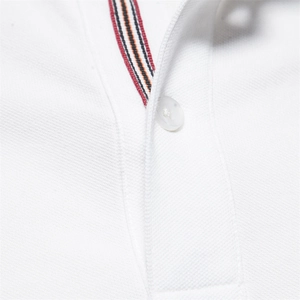 White cotton polo shirt detail featuring embroidered deer and striped placket accents