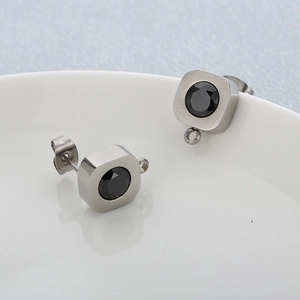 Détail de boucles d'oreilles carrées argentées avec cristal noir et petits anneaux