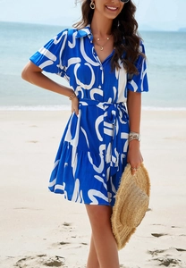 Detail view of a blue and white geometric print dress with short sleeves and a belted waist