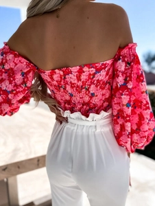 Detail of the elastic smocked back on a pink floral off-shoulder long sleeve blouse