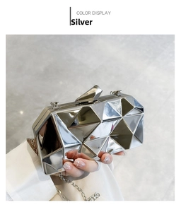Detail of silver geometric acrylic clutch bag with shiny finish and fine metal chain