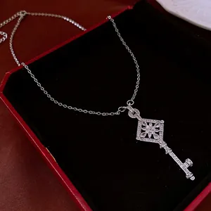 Silver-toned key pendant necklace with diamond-shaped zircon flower in a black jewelry box