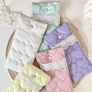 Detailed close-up of quilted heart pattern and lace trim on colorful glasses pouches