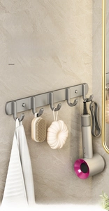 Close-up of 5-hook matte silver aluminum rack for bathroom storage on marble wall