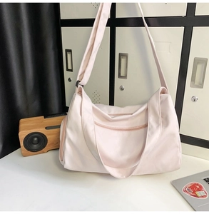 Détail d'un grand sac de sport rose avec bandoulière réglable et double fermeture éclair