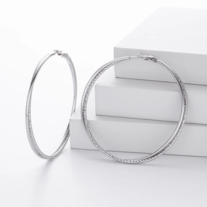 Detailed macro shot of large S925 sterling silver hoop earrings on a white background