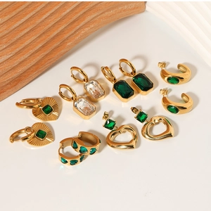 Detail of vintage heart and emerald zircon gold earrings on elegant display stands