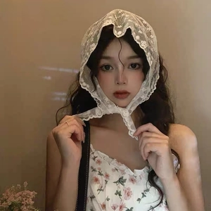 Close-up of a white lace triangle bandana featuring delicate floral embroidery and ties
