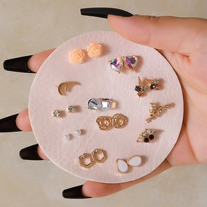 Set of 12 pairs of geometric gold earrings with pearls and crystals on display card
