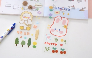 Close-up of cute transparent PVC duck and rabbit stickers on an open children's book