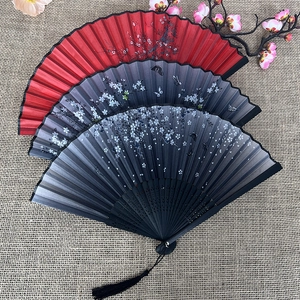 Traditional Japanese style folding fans with cherry blossom patterns and elegant tassels