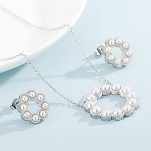 Dettaglio macro di set collana e orecchini con corone di perle in argento