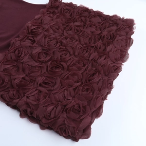 Détail de broderies de roses 3D bordeaux sur le tissu en mesh de la robe