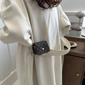 Minimalist dark brown mini crossbody bag with geometric embossing and gold chain strap