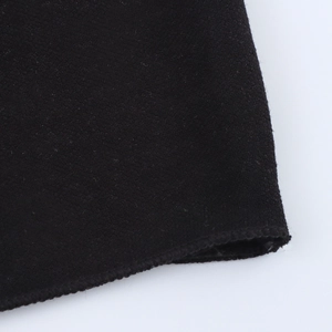 Close-up of black fleece fabric texture with professional overlock stitching detail
